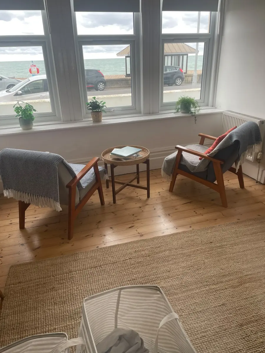 Bright sitting room with two armchairs and a sea view, finished and guest-ready